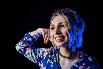 Infantile girl on a black background in blue light