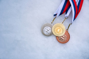Gold silver and bronze medal set on white snow, medal ceremony on winter game, sport photo, white...