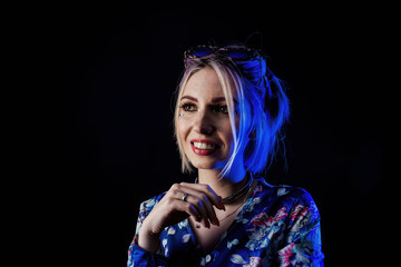 Infantile girl on a black background in blue light