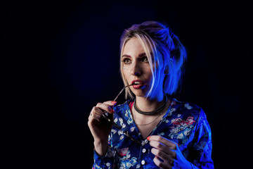 Obraz premium Infantile girl on a black background in blue light