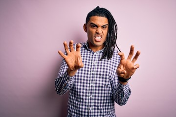 Young handsome african american afro man with dreadlocks wearing casual shirt smiling funny doing...