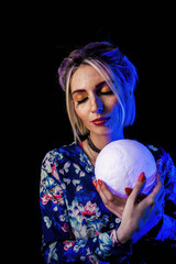 Naklejka premium Infantile girl on a black background in blue light