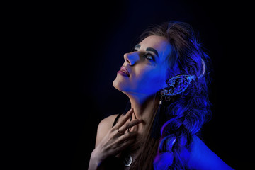 Girl in werewolf style on a black background with blue light