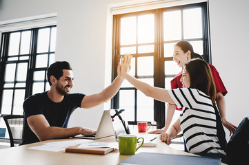 Obraz premium Successful entrepreneurs and business people achieving goals. Happy corporate team giving high five gesture as they laugh and cheer their succeed