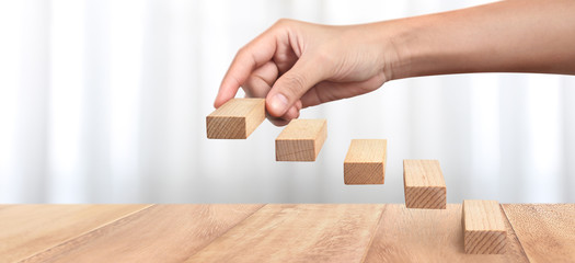 Hand liken person stepping up  toy staircase wood