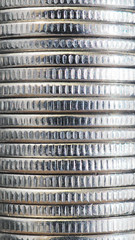 Background from stacks and edges of nickel white coins close-up. Vertical textured backdrop or...