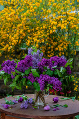 A bouquet of purple lilca on a white table