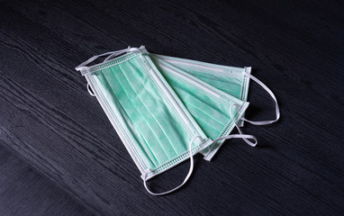 Disposable surgical face mask use for cover mouth and nose, and hand sanitizer spray in clear bottle for protection against flu, corona virus(COVID-19) and other diseases on black background.