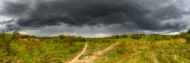 Dramatic view of a shelf cloud over a field, horizontal cloud formation, panorama view.