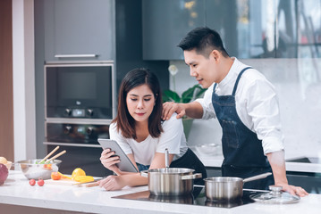 Young Adult Couple Food Cooking Together in the Kitchen at Home