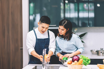 Young Adult Asian Couple Cooking Together and Washing Vegetables and Fruits in the Kitchen - Housework and Lifestyle Concept