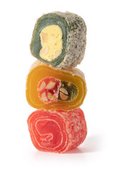 Three pieces of different Turkish delight on a white background