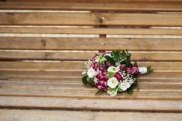Wedding bouquet on a wooden bench in red colors