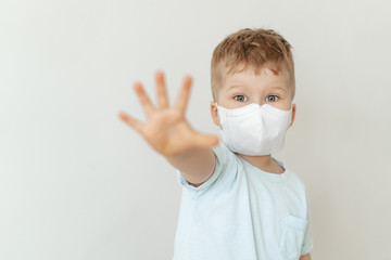 Toddler Boy Wearing Medical Flu Mask Portrait. Cute Child Showing Stop Sign Looking at Camera Selective Focus. Safe Social Distance Concept. Outbreak Prevention. Corona Virus Pandemic