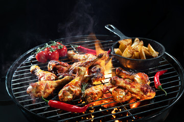 Grilled chicken legs or drumsticks on the hot flaming grill
