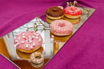 multi-colored donuts on a mirror surface