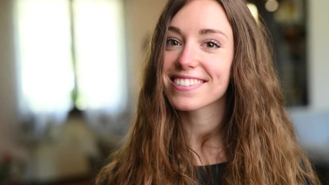 Giovane bella ragazza sorride in camera a casa