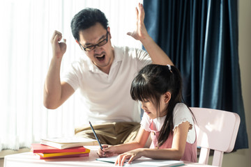 Homeschool Asian young little girl learning, reading and does homework with mean dad strictly ...