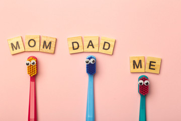 Kids toothbrushes of different colors on a pink background. Teeth and oral hygiene for children