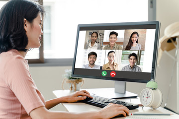 Asian business woman talking to colleague team about plan in video conference. Group of multiethnic business people using computer for online meeting in video call conference. Smart working from home.