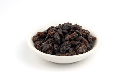 Dried black raisin in white bowl isolated in white background.