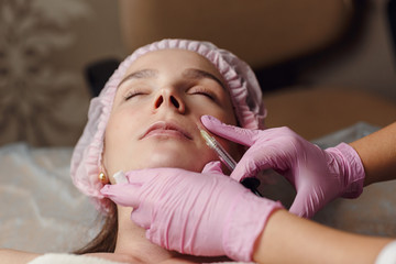 Beautiful girl on rejuvenation procedure in beauty clinic filler injection.