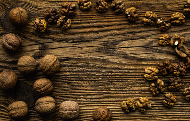 Walnut scattered on the wooden vintage table. Walnuts is a healthy vegetarian protein nutritious food. Walnut on rustic old wood.