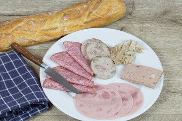 assiette de charcuterie et baguette de pain sur une table