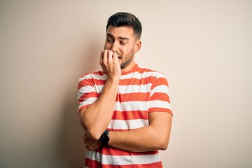 Young handsome man wearing casual striped t-shirt standing over isolated white background looking...