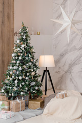 Big Christmas tree with gifts in a white room