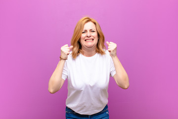 middle age woman shouting aggressively with annoyed, frustrated, angry look and tight fists,...