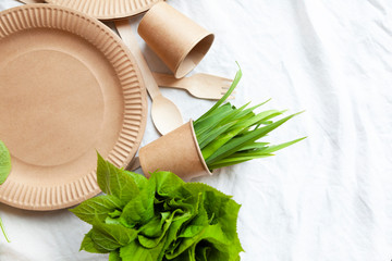 disposable eco tableware on a light background of paper cardboard spoon fork knife