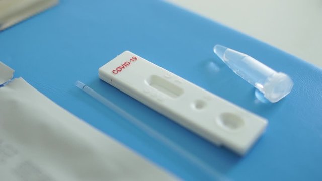 Doctor lays out a kit for the diagnosis of sars-cov-2 coronovirus - test cassette, reagents, scarifier and disinfectant wipe. Express Test Coveid-19