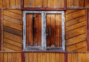 Window - yellow , red and orange paint on old wooden house wall