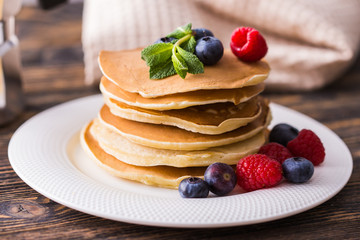 Close-up delicious pancakes with fresh blueberries and raspberries.