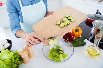 Cropped close-up view of her she nice girl housewife housemaid cooking lunch dinner dish snack chopping knife on wooden board over table desk in modern light white interior kitchen house