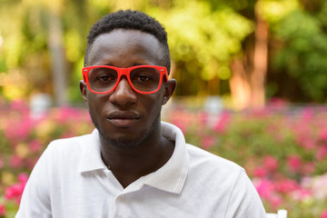 Face of young African man with eyeglasses at the park outdoors