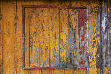 yellow , red and orange paint on old wooden house wall