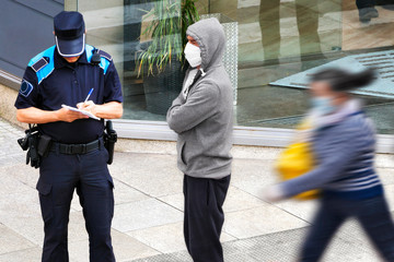 policeman writing fine ticket for man  for not respecting the quarantine in pandemic coronavirus...