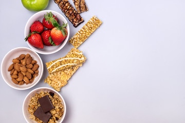 Bowls with Granola or Muesli Bowl with Strawberry and Almond Muesli Bars Blue Background Healthy Diet Breakfast Top View Flat Lay Copy Space