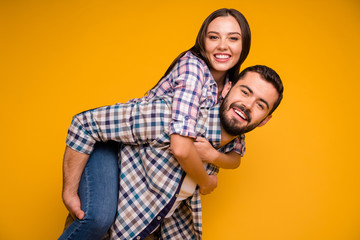 Portrait of cheerful passionate spouses man carry woman piggyback enjoy summer rest relax wear checkered outfit isolated over bright shine color background