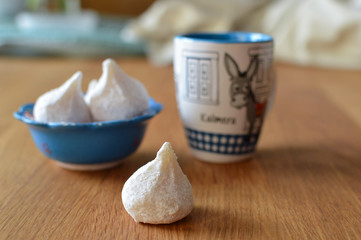 Traditional Greek almond cookies pear shape, amygdalota, typical for Cyclades, in a blue bowl, and coffee mug with Greek donkey, selective focus
