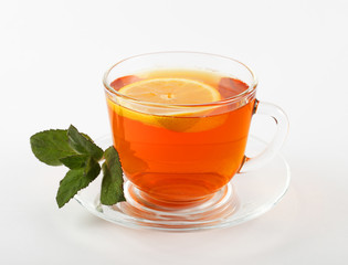 glass mug of tea with mint leaves and lemon, white background, isolate