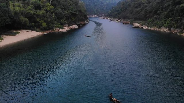 4k Aerial Tilt Up olly Reveal Shot of a Fisherman paddling his boat in the crystal clear waters of Shnongpedang, Dawki River