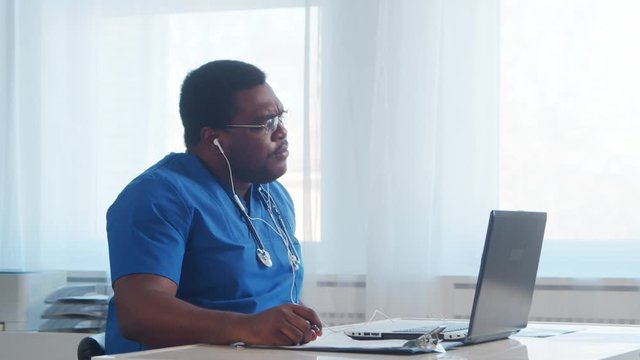 Professional african american medical doctor working in hospital office using computer technology. Medicine and healthcare.