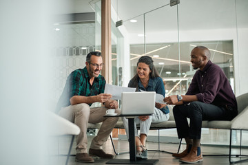 Casual meeting of smiling diverse business team analyzing financial data - obrazy, fototapety, plakaty