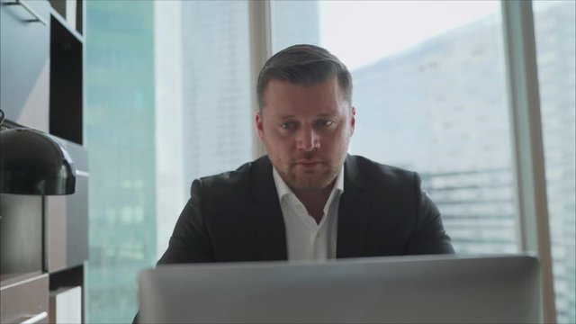 A businessman is concerned about the crisis. Focused serious businessman in suit thinking reading online news or solving business problem working on laptop looking at screen, worried puzzled executive
