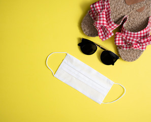 Beach accessories and mask on yellow background.