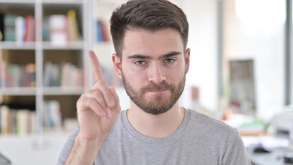 Portrait of No, Young Man rejecting by Waving Finger