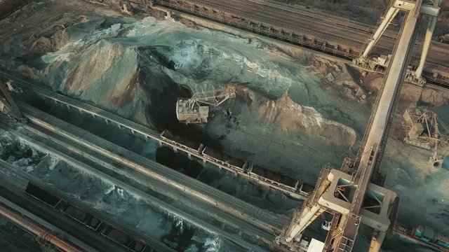 Industry manufacturing excavator loading a train aerial video 4K.